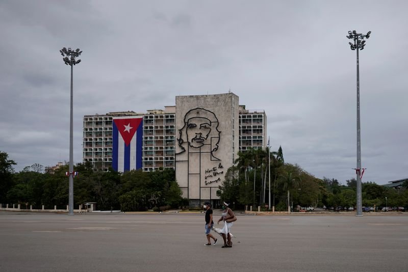 Foto de archivo. Gente camina en la plaza de la Revolución cerca de una imagen del fallecido revolucionario Ernesto "Che" Guevara, en medio de la preocupación por la propagación del brote de la enfermedad coronavirus (COVID-19), en La Habana, Cuba. 1 de mayo de 2020. REUTERS/Alexandre Meneghini