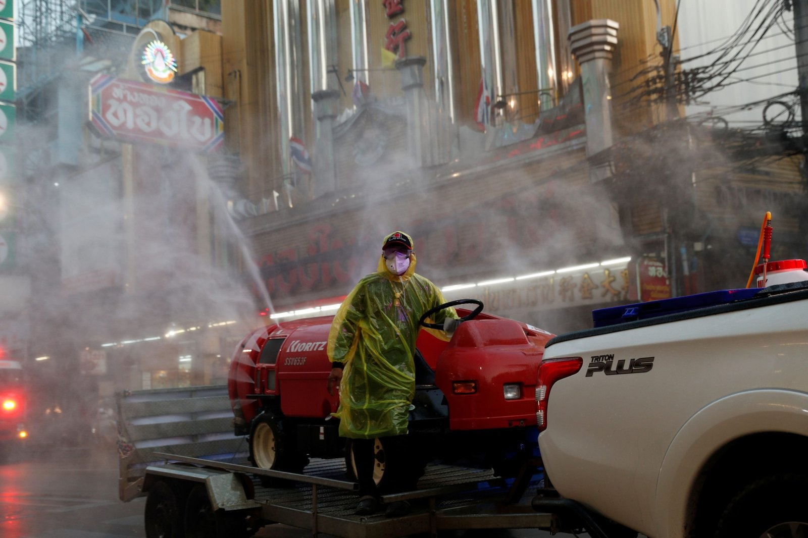 Un hombre con una máscara facial protectora y un traje fumiga el barrio chino de Bangkok, Tailandia (Reuters)