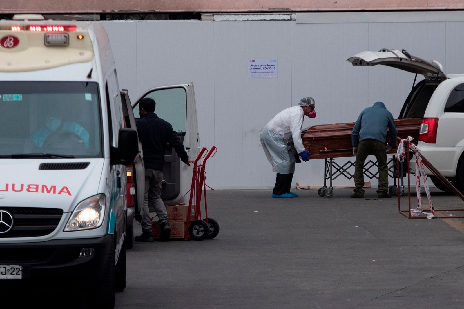 Trabajadores del Hospital San José y operarios funerarios trasladan el cuerpo de un fallecido, este martes en Santiago (Chile). EFE/ Alberto Valdés
