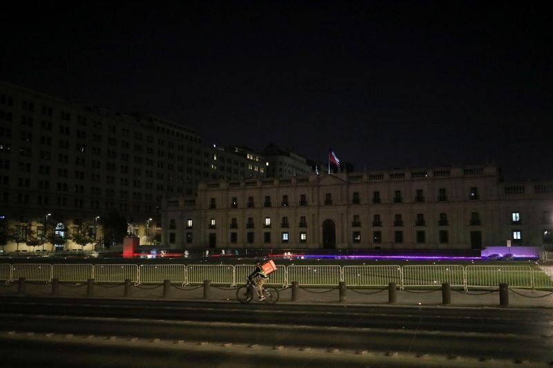 Imagen de archivo de un repartidor pasando en su bicicleta frente al palacio presidencial chileno de La Moneda, en pleno brote de coronavirus en Santiago, Chile, el 27 de marzo de 2020. REUTERS/Pablo Sanhueza