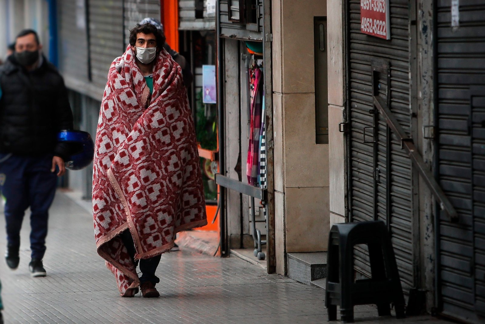 Transeúntes caminan frente a un comercio cerrado en la capital argentina. EFE/Juan Ignacio Roncoroni/Archivo