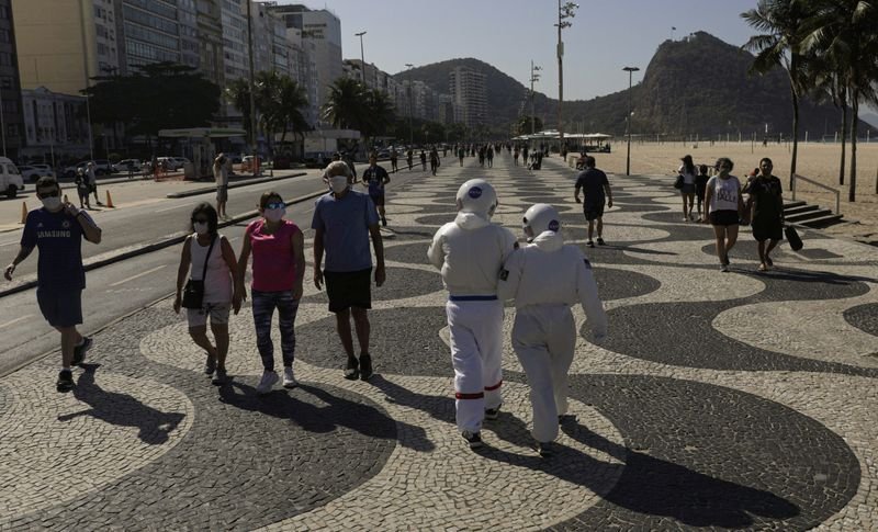 Tercio Galdino, de 66 años, y su esposa Aliceia, de 65 años, usan "trajes espaciales" protectores mientras caminan por la acera de la playa de Copacabana, Río de Janeiro, Brasil, 11 julio 2020.
REUTERS/Ricardo Moraes