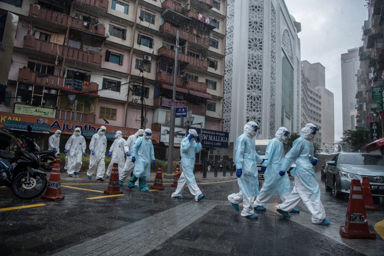 06 April 2020, Malaysia, Johannesburg: Employees of the Ministry of Health leave a building after testing the residents for the coronavirus. Photo: Mustaqim Khairuddin/BERNAMA/dpa