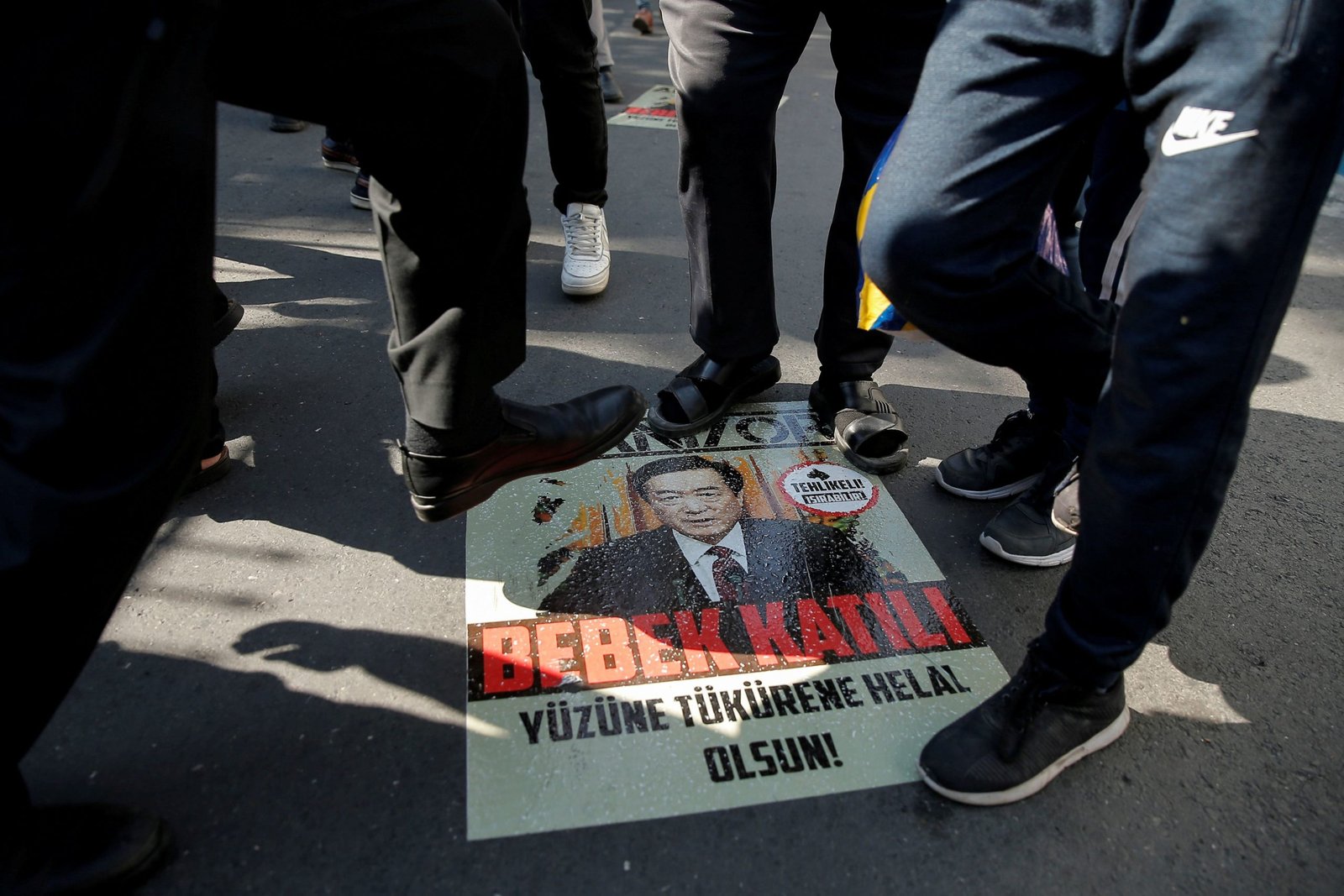 Manifestantes étnicos uigures pisan un cartel con una imagen del Secretario del Partido Comunista de la Región Autónoma Uigur de Xinjiang Chen Quanguo durante una protesta contra China frente al Consulado de China en Estambul, Turquía, 1 de octubre de 2019 (Reuters)