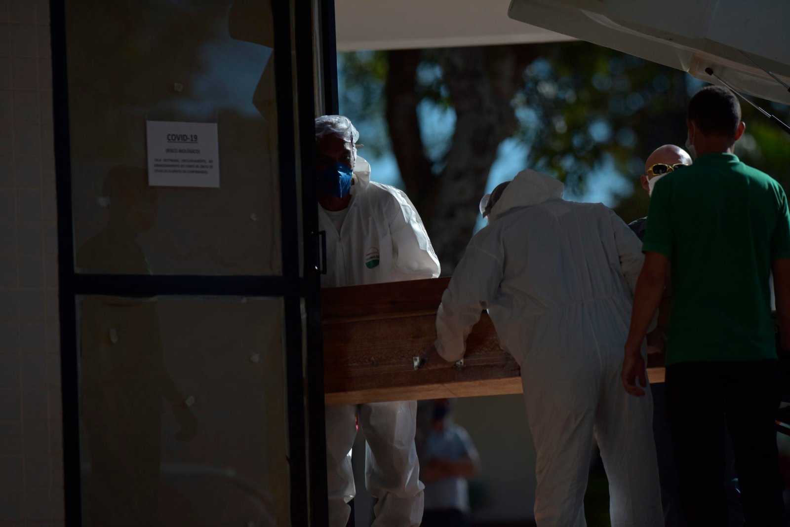 En la imagen, personal de servicios funerarios trasladan un ataúd a un lugar destinado para víctimas por Covid-19, donde permanecen hasta el momento del funeral en Brasilia. EFE/Andre Borges
