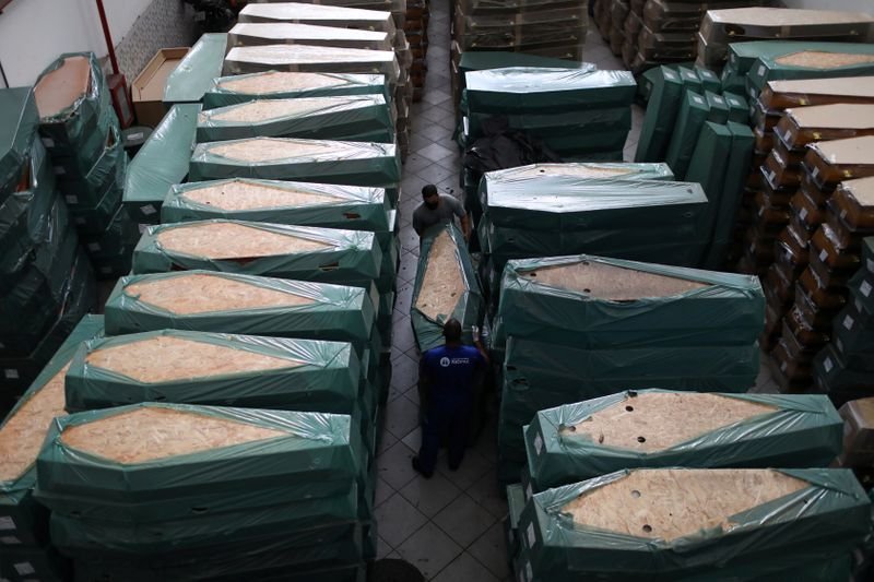 Trabajadores mueven un ataúd en una bodega de la compañía funeraria Rio Pax, en medio del brote de coronavirus en Río de Janeiro el 3 de julio de 2020 (REUTERS/Pilar Olivares)