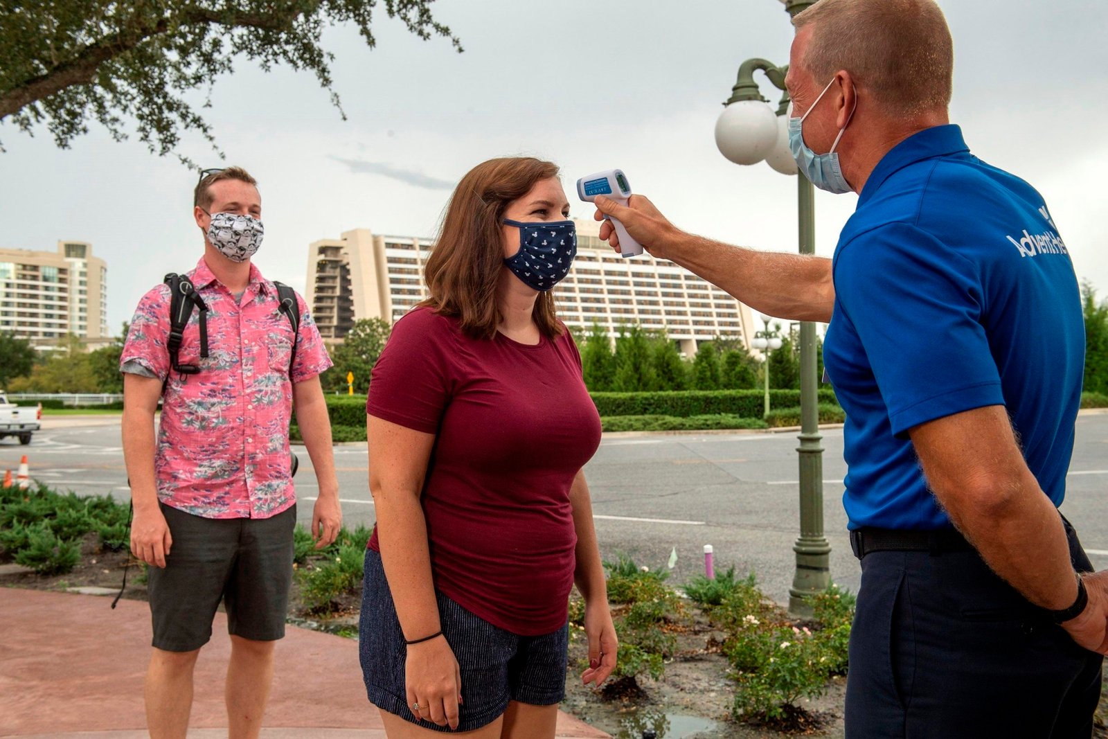 Fotografía sin fecha cedida por Disney donde aparece uno de sus empleados tomando la temperatura a una visitante en la entrada de una atracción en el Walt Disney World Resort en Lake Buena Vista, Florida (EEUU). EFE/Kent Phillips/Disney
