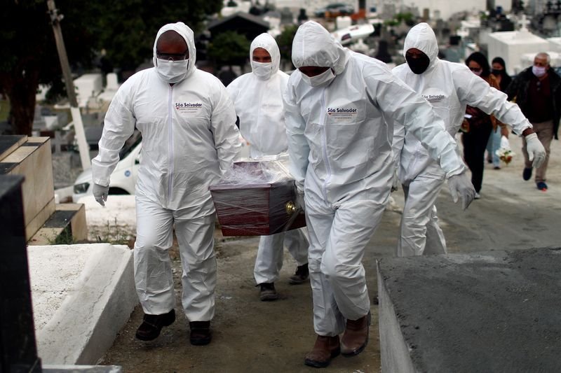Funcionarios de un cementerio vistiendo ropa de protección durante el entierro de una víctima por COVID-19, en Nova Iguaçu, Río de Janeiro, Brasil, el 16 Julio de 2020 (REUTERS/Pilar Olivares)