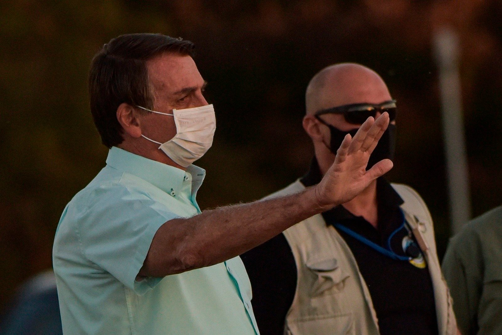 En la imagen, el presidente de Brasil, Jair Bolsonaro (i), saluda a partidarios durante la bajada de bandera, ayer 21 de julio del 2020, en el Palacio do Alvorada, en Brasilia (Brasil). EFE/Andre Sousa Borges
