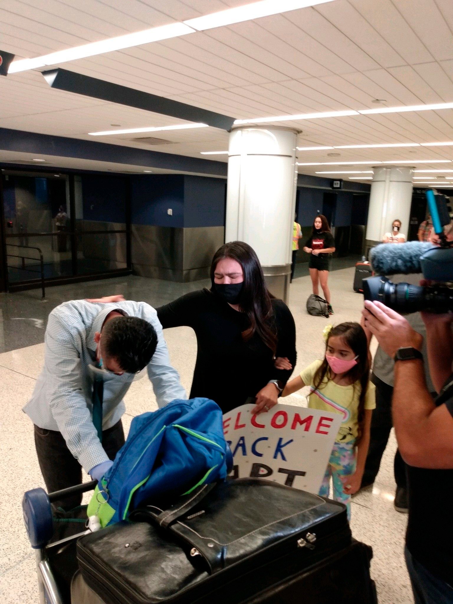 Fotografía cedida por la abogada Meredith Brown de Marlon Castillo, su esposa Ana Castillo y su pequeña hija oran en el el Aeropuerto Internacional de Los Ángeles, tras la llegada del migrante guatemalteco al país. EFE/Meredith Brown