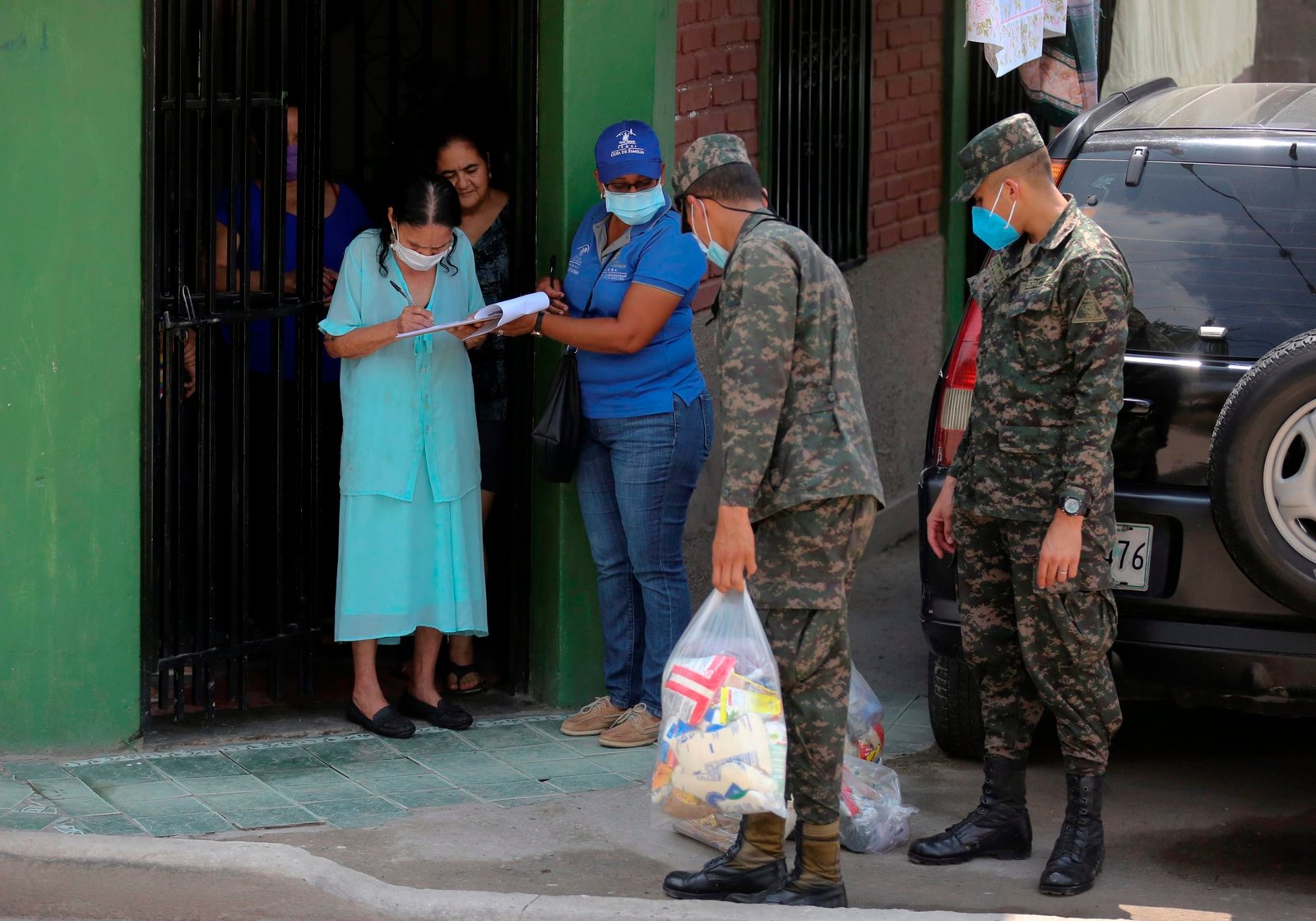 Un militar hondureño carga una ración de comida para entregarla una familia en el barrio marginal La Betania en Tegucigalpa(Honduras). EFE/Gustavo Amador/Archivo
